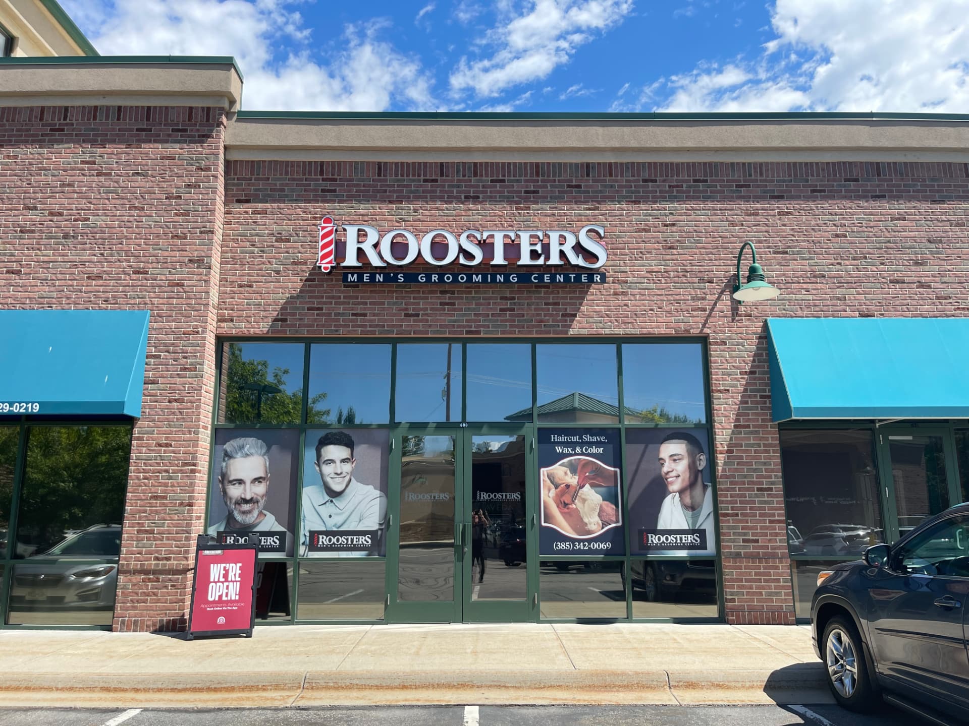 Roosters Men's Grooming Center storefront with red barber pole sign