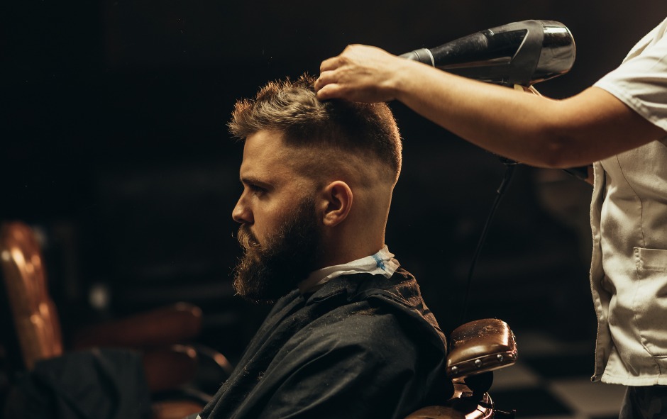 Barber blow-drying a bearded guest's hair