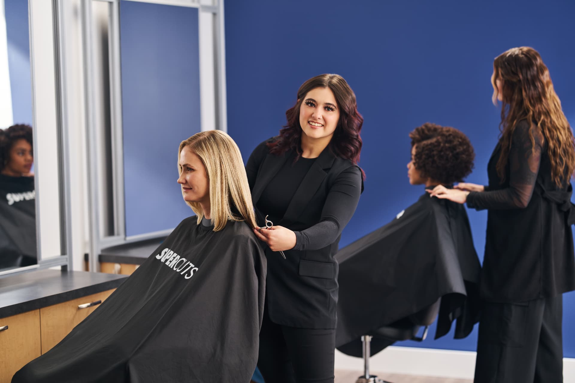 Stylist finishing a cut at a bright salon station
