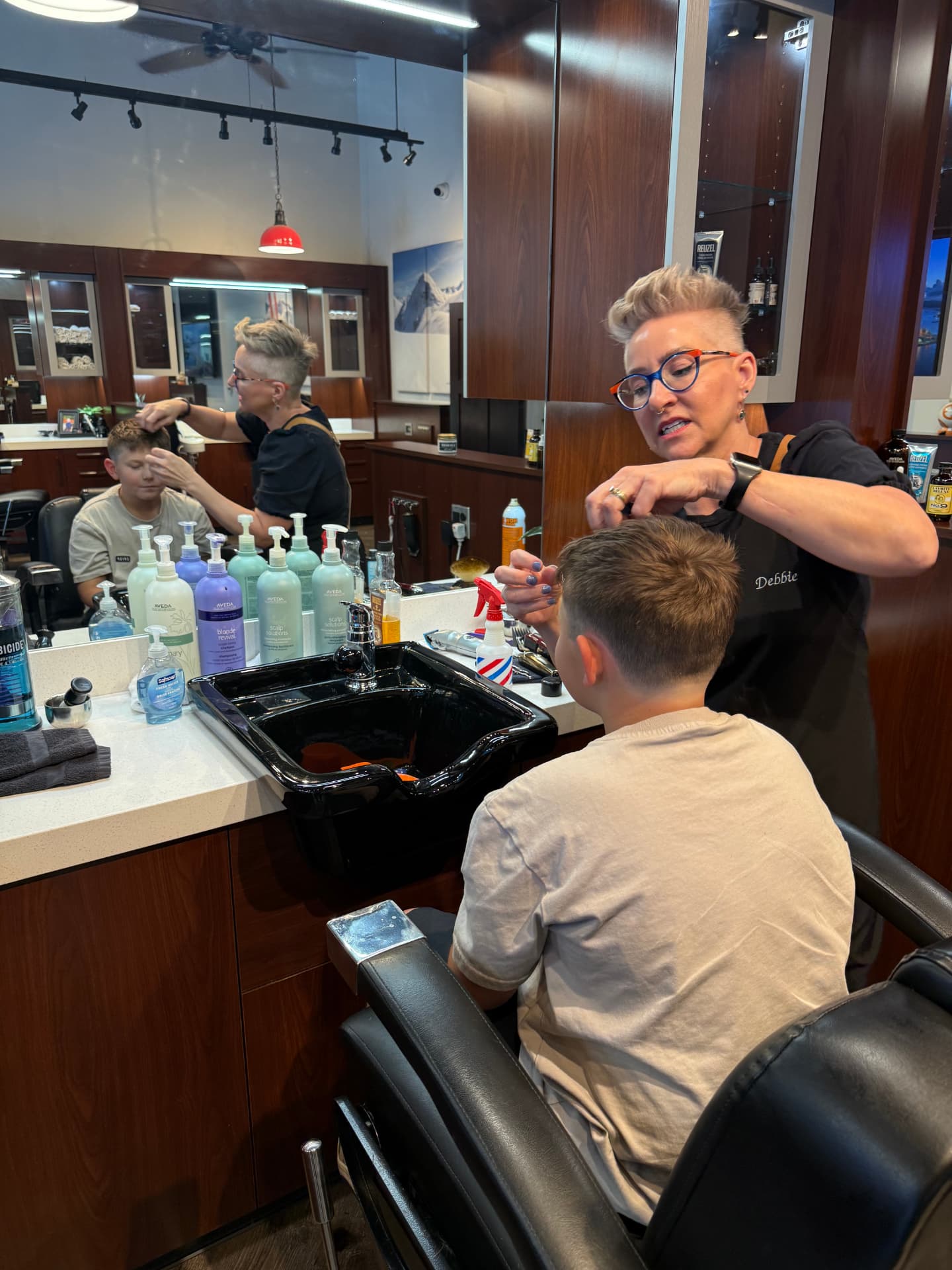 Barber finishing a young guest's cut